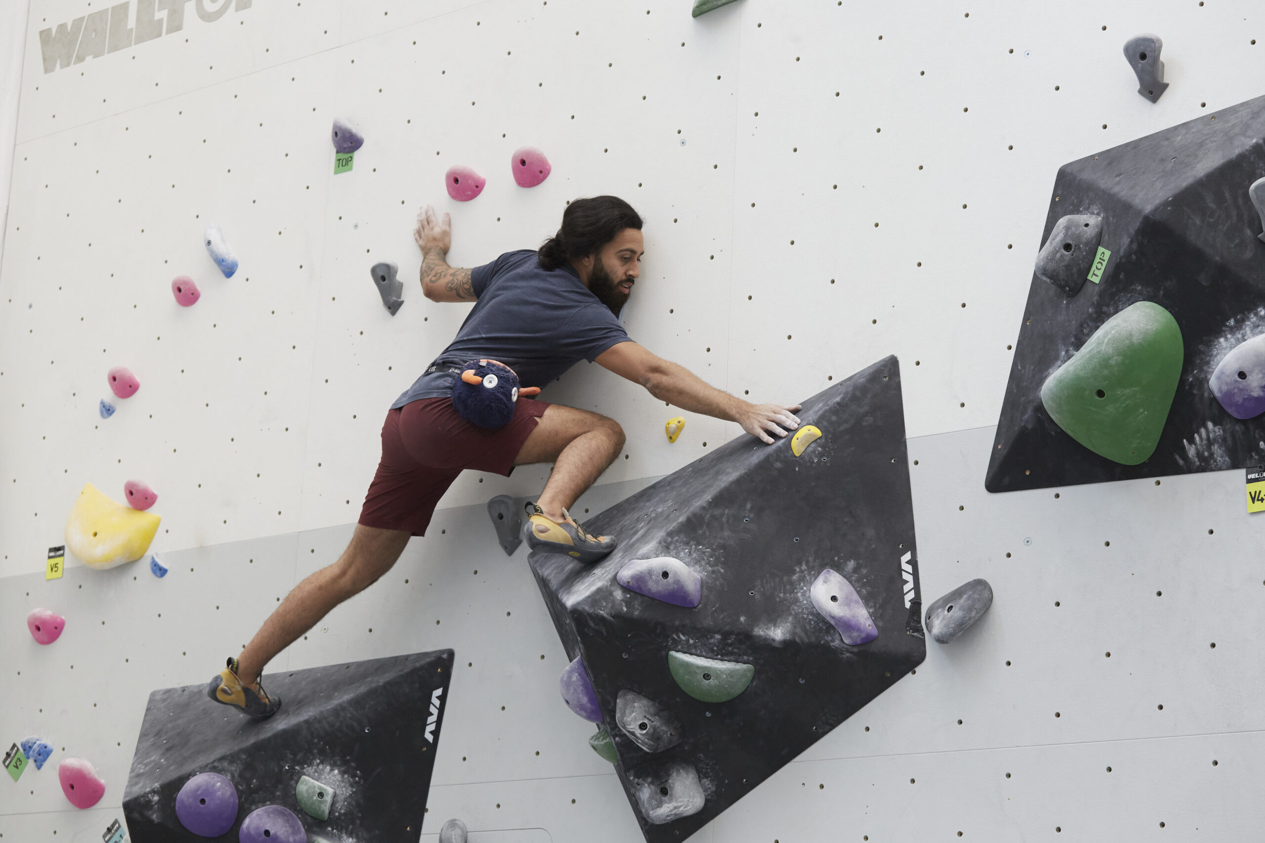 a climber keeping a stable body position on a tricky boulder at Velocity Climbing